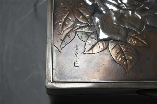 A Japanese silver, copper and gold cigarette box, Meiji period, decorated with a panel of roses, signed, 22 x 14.5cm, height 8cm